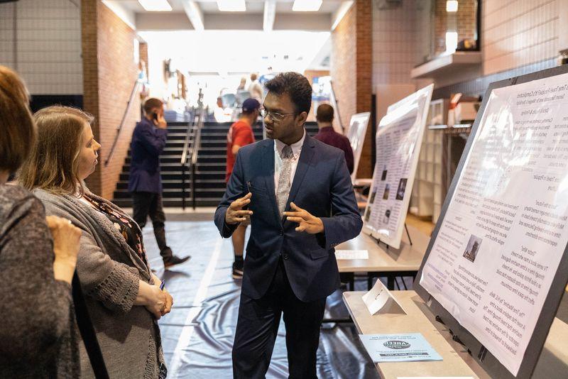 Male student presents research project to two females
